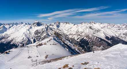 Fototapeta na wymiar Panorama of winter snowy mountains in Caucasus region in Russia with ski lift and ski track