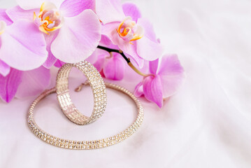 Bracelet and necklace on white fabric and purple Orchid
