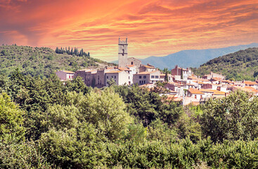 Fototapeta na wymiar Rural village located on top of a hill at sunset