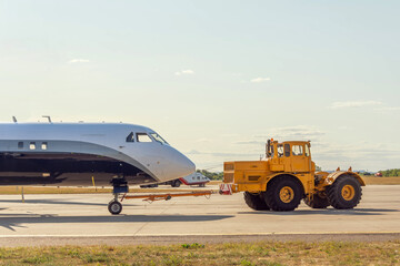 Aircraft is pushed backwards over the roll rock with an aircraft tractor, side view.