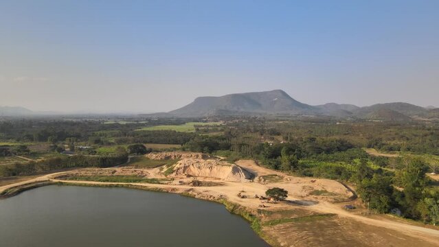 Aerial Panning Shot of a Lake and Mountainous Background in Phetchaburi, Thailand.