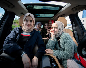 Muslim female friends enjoying road trip traveling at vacation in the car. High quality photo