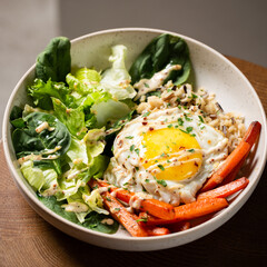 Plate with breakfast salads: brown rice, carrots, egg