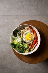 Plate with breakfast salads: brown rice, carrots, egg