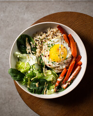 Plate with breakfast salads: brown rice, carrots, egg