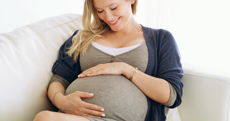 I never knew how lucky I could be. Shot of a pregnant woman holding her belly at home.