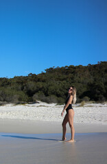 side portrait of young woman in bikini and sunglasses on beach in Australia