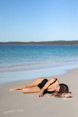 asleep young woman in black bikini and on beach