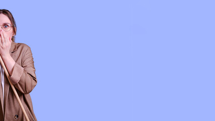 Scared woman teacher with pointer on studio blue background, banner copy space