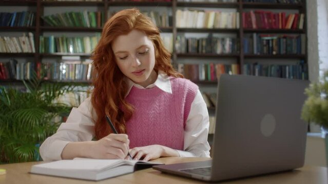 Young Student Woman Study With Online Lesson in the Home Office or Library Talk Conference Calling do Video Chat, Make Notes Sit at Home Office Desk Look at Laptop Computer