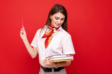 A young woman in a white shirt with diaries on a red background