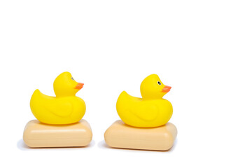 Yellow rubber ducklings and two pieces soap white background.Bathing baby and cleanliness.