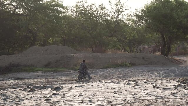 Large man approaching wood shack in Popoyo beach Nicaragua going over beach sand, Pan right follow shot
