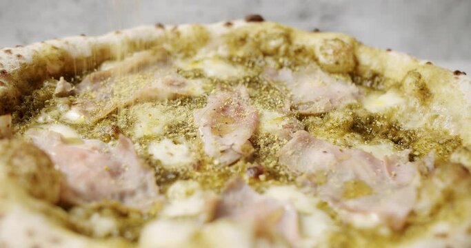Pizza with Meat, Pesto, Cheese and Parmesan fresh out of the oven ready to eat. Delicious Italian pizza. Napoli Pizza. Food Service on white table and ingredient. Tasty Pizza with Cheese and Parmesan.