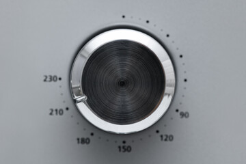 Close-up Circular button to control the temperature in the microwave oven. Button to warm food on gray background
