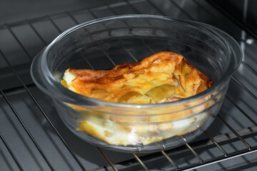 Apple pie in a transparent bowl in the microwave, oven