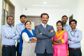 Diverse Indian corporate employees with arms crossed standing looking at camera at office - concept of teamwork, workforce, business development and collaboration.