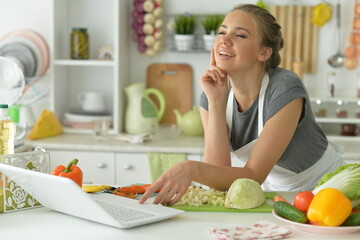 cute girl making salad  on kitchen