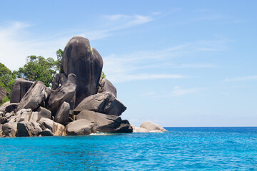 Fototapeta premium Landscape with bizarre giant rocks in turquoise water of Andaman Sea near Similan islands in Thailand. Beautiful tropical seascape. Travel, tourism and resort background.