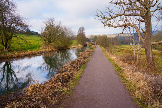 Down the Cromford Canal towpath towards a stone bridge.