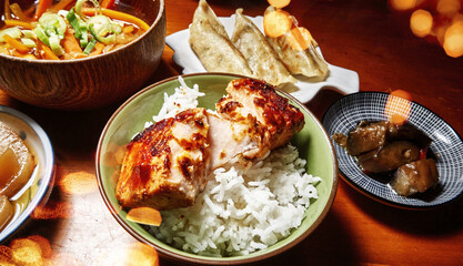 Japanese food in small bowls with rice, salmon, gyoza and eggplant