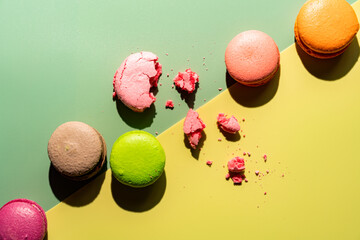 Cookie macaron or macaroon on colorful bright background from above. Multicolored almond cookies...