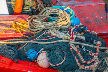 A fishing net with ropes and cord on the deck of a Fisherman's boat