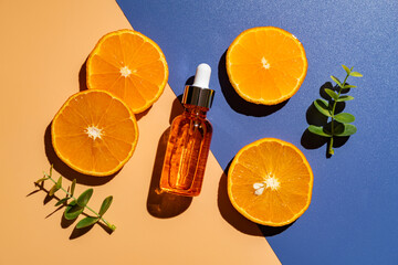 Citrus fruit vitamin c serum oil beauty care, anti aging natural cosmetic with fresh orange fruits on blue background, top view