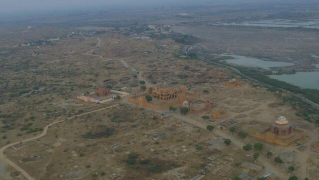 Aerial rotating shot over the Tomb Of Dewan Shurfa Khan on Makli Hill in rural countryside in Thatta , Pakistan at sunset.