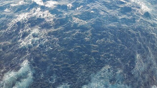 Sea water to the sides of a cruiser while navigating. Effects from the engines propulsion can be seen on the water sruface on the shape of white marks from air and small waves.