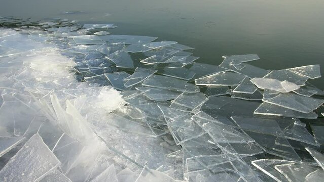 Ice being pushed up along the edge of Utah Lake in winter as sheets make noise trying to break into place.