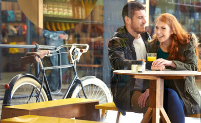 Love and laughter. Cropped shot of a happy young couple on a date at a cafe.