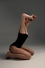 Obraz premium Beautiful and slim girl warming up on a white background