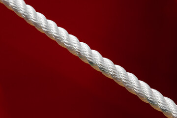 White rope diagonally on a red background.