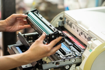 Women holding Laser toner cartridge ,replacing toner in laser printer at office. Repairs and Maintenance printers concept ,selective focus - obrazy, fototapety, plakaty