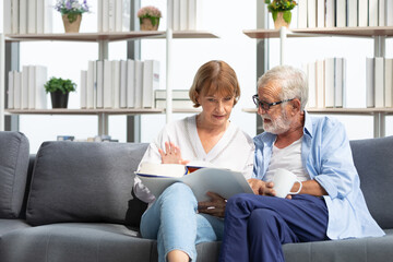 Fototapeta premium senior couple reading a book and self learning in living room