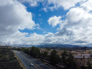 Fototapeta premium An Aerial UAV Drone Image of the Crafton Hills Area of Yucaipa, California, with Stacked Clouds During a Winter Storm and Snow on the Mountains