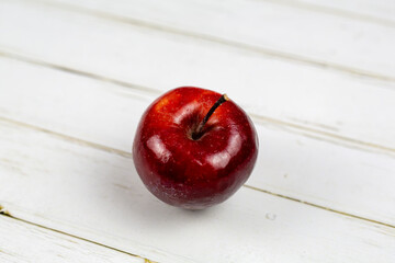 Roter Apfel auf weißem Holz