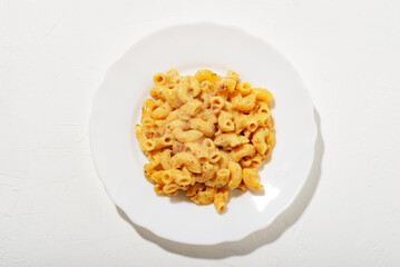 curly pasta with sauce on a white plate. Minimalism. White background. Pasta in cheese sauce. View from above.
