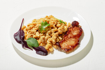 Pasta in cheese sauce with chopped meat and lettuce. Minimalistic food design. White background.