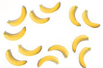 Fototapeta na wymiar Background from bananas on a white background. View from above. Lots of yellow bananas. Minimalistic design.