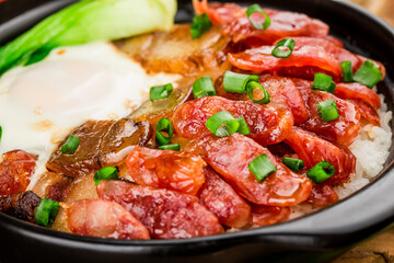Cantonese style cooking of claypot rice with waxed meats