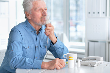 Portrait of ill senior man portrait with inhaler