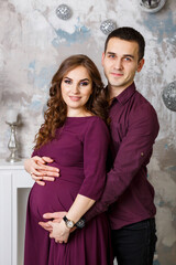 Image of husband standing and holding belly of pregnant wife hands. Woman, girl and loving handsome man hugging tummy at home. Loving Couple. Parenthood concept. Baby Shower. Family photo.