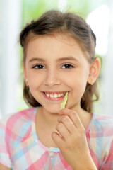 Cute girl eating delicious fresh salad in kitchen