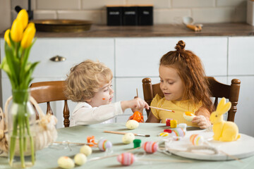 Obraz na płótnie Canvas Two little children paint Easter eggs
