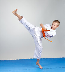 Obraz na płótnie Canvas Sportsman with a orange belt beats kicking