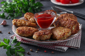 Cutlets of turkey fillet and oatmeal, fried in a pan, served with tomato sauce