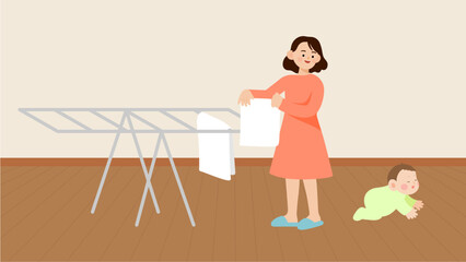 Mother hanging laundry and cute baby crawling