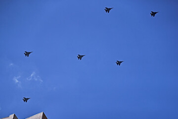 Group of Russian army air force shows aerobatics in blue sky. Parade of military aircraft over the city.